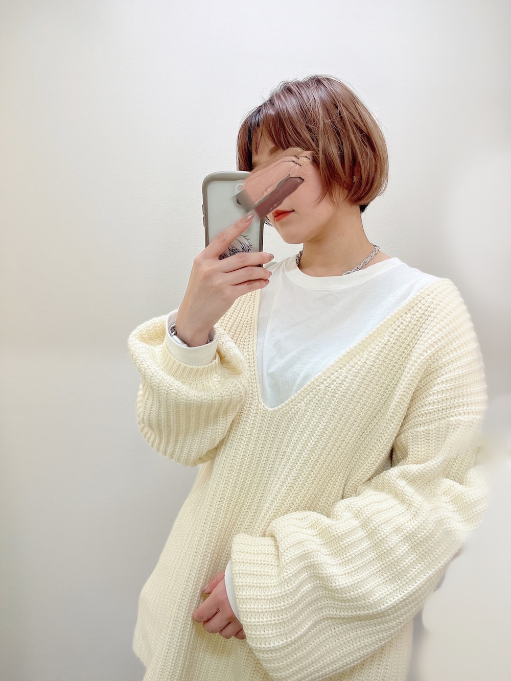 ベージュ系のその他パンツ、ホワイト系のニット/セーター、ブラック系のサンダルを着用したレディースの春コーディネートの2枚目の写真