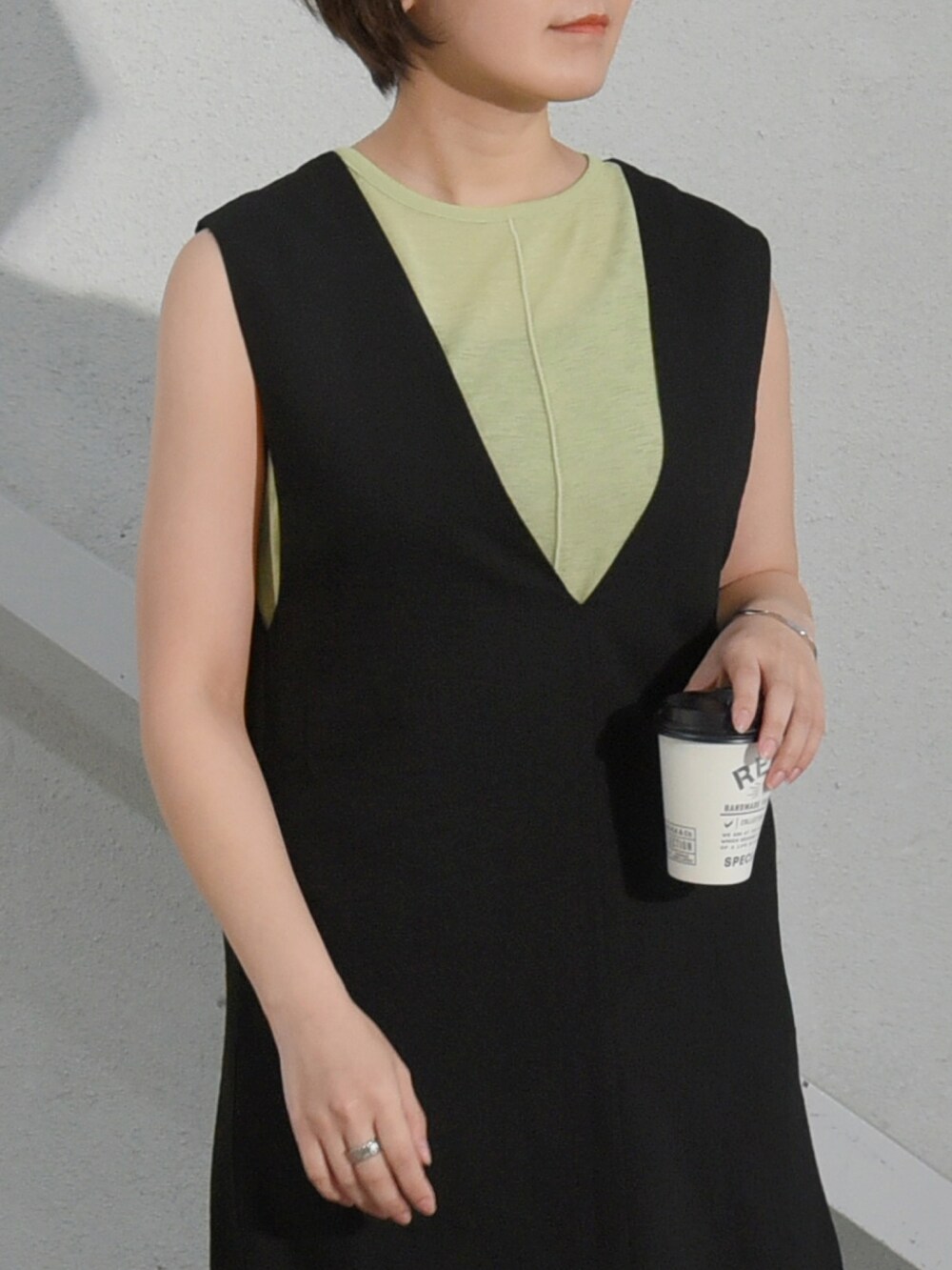 グリーン系のタンクトップ、ブラック系のサンダル、ブラック系のスカートを着用したレディースの夏コーディネートの2枚目の写真