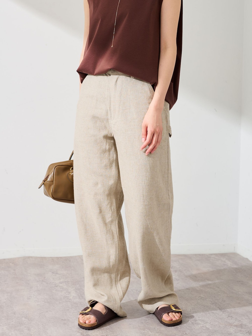 ベージュ系のデニムパンツ、ブラウン系のTシャツ/カットソー、ブラウン系のショルダーバッグを着用したレディースの夏コーディネートの3枚目の写真