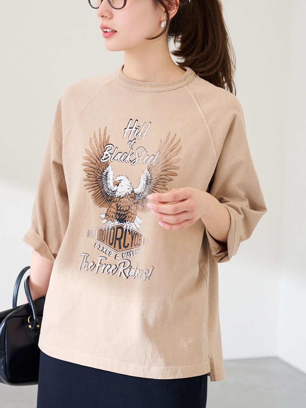 ブラック系のスカート、ベージュ系のTシャツ/カットソー、ブラック系のショルダーバッグを着用したレディースの冬コーディネートの3枚目の写真