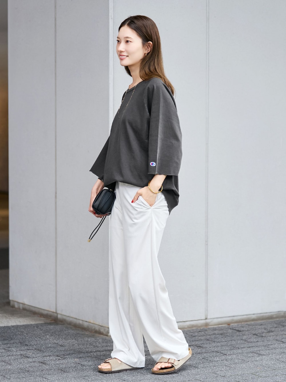 ホワイト系のその他パンツ、ブラック系のTシャツ/カットソー、ブラック系のショルダーバッグを着用したレディースの夏コーディネートの2枚目の写真