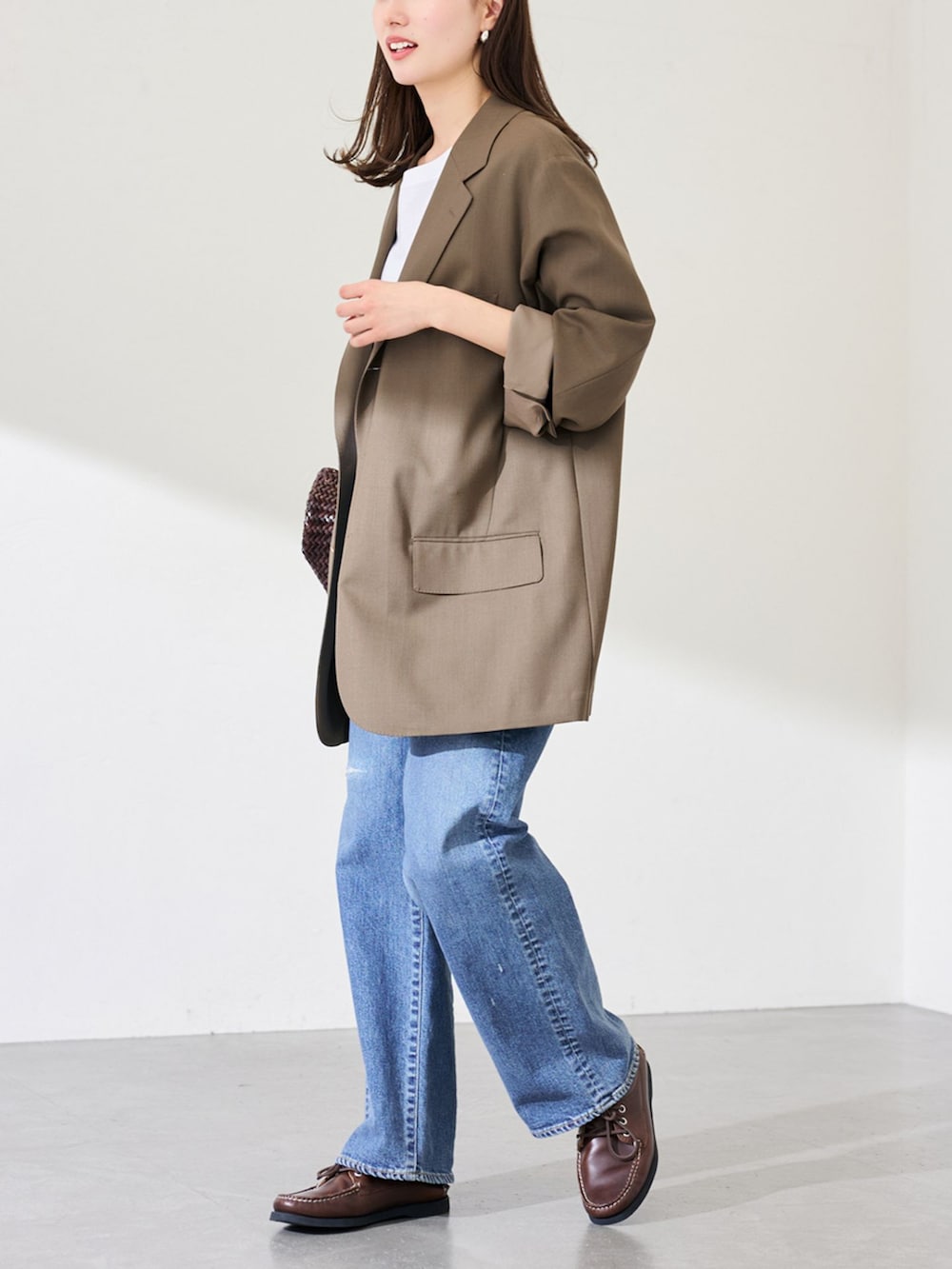 ブラウン系のその他シューズ、ブラウン系のその他アウター、ブルー系のデニムパンツを着用したレディースの冬コーディネートの2枚目の写真