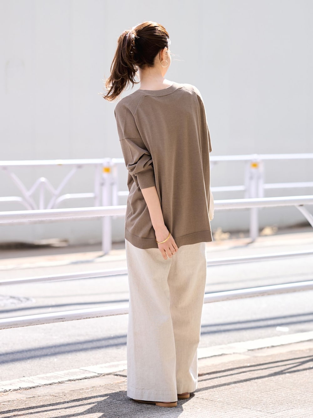 ベージュ系のその他パンツ、ブラウン系のカーディガン/ボレロ、ホワイト系のボストンバッグを着用したレディースの春コーディネートの3枚目の写真