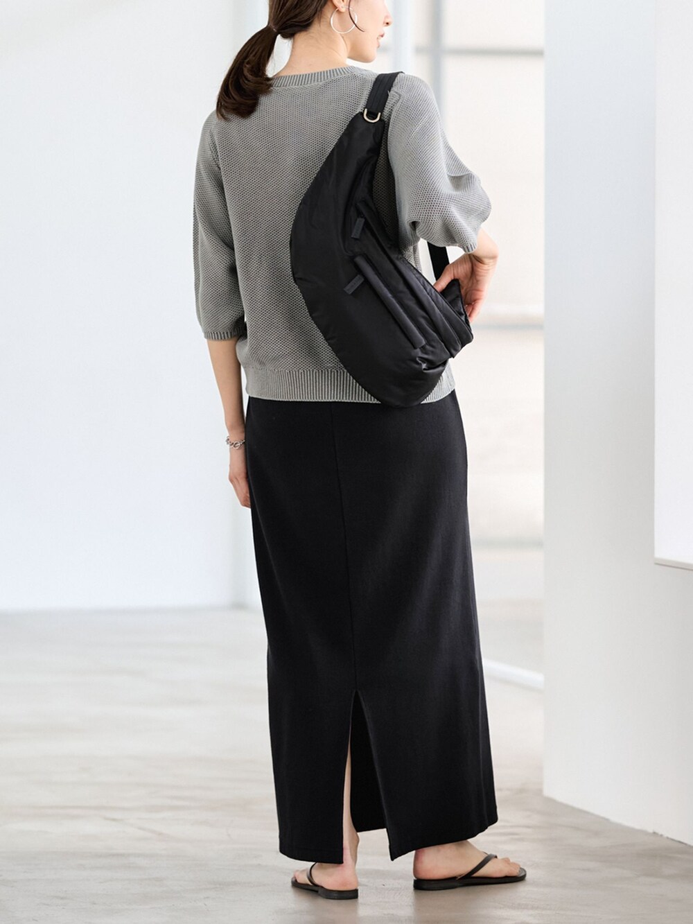 ブラック系のスカート、グリーン系のニット/セーターを着用したレディースの冬コーディネートの3枚目の写真