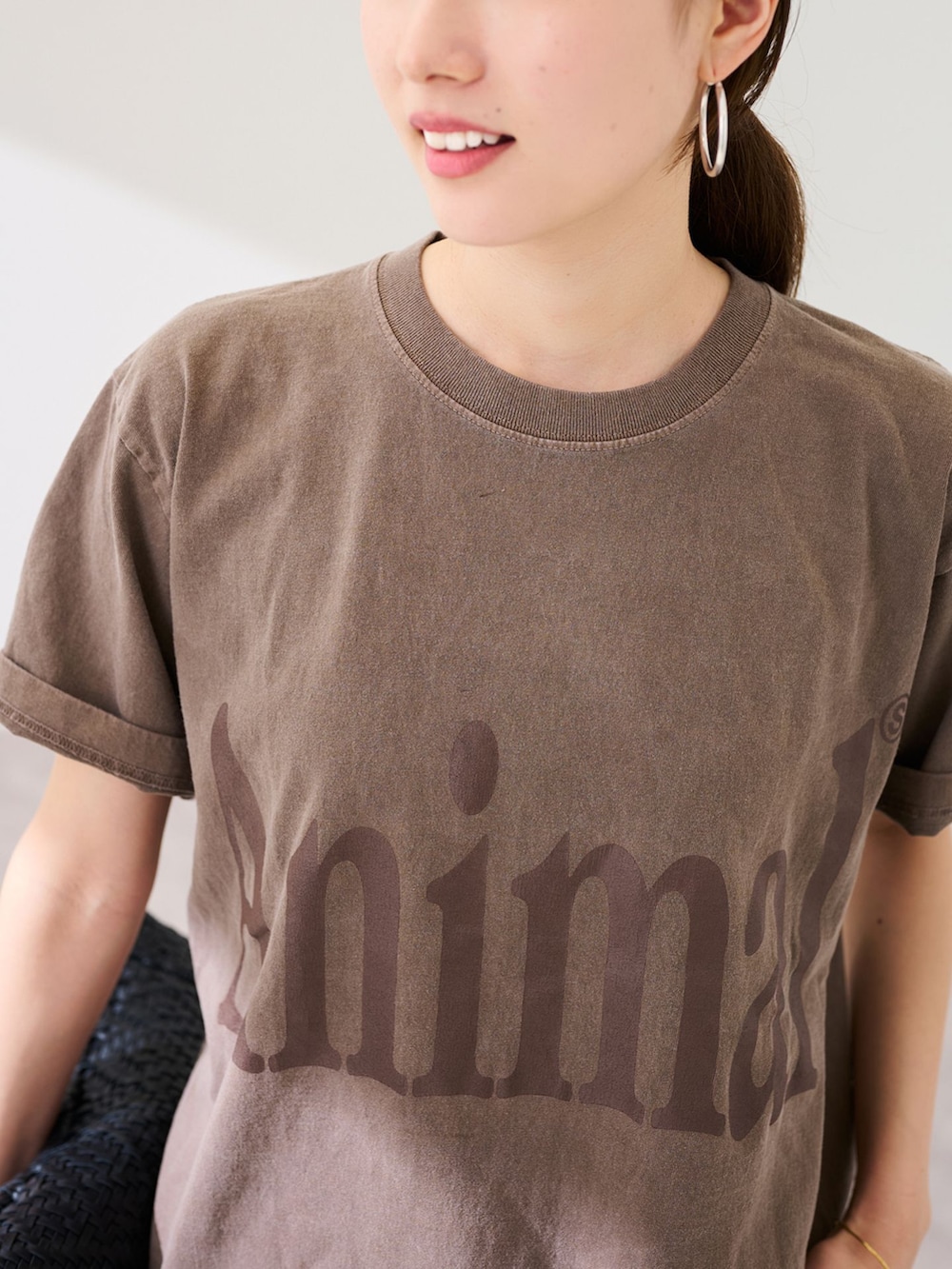 ブラック系のスラックス、ブラウン系のTシャツ/カットソー、ブラック系のトートバッグを着用したレディースの春コーディネートの8枚目の写真