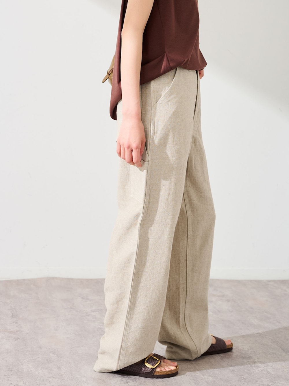 ベージュ系のデニムパンツ、ブラウン系のTシャツ/カットソー、ブラウン系のショルダーバッグを着用したレディースの夏コーディネートの4枚目の写真