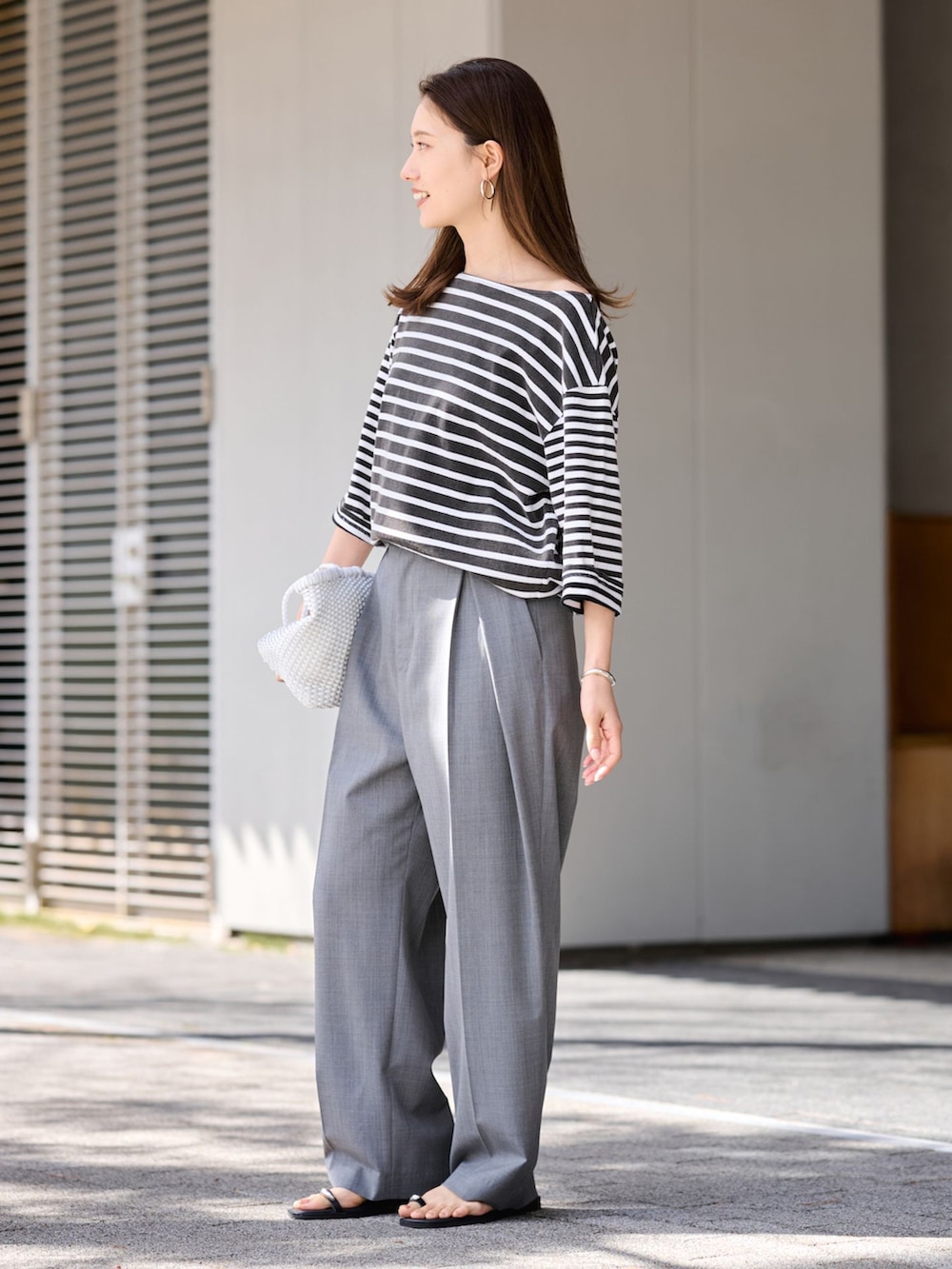 グレー系のスラックス、ブラック系のTシャツ/カットソーを着用したレディースの春コーディネートの2枚目の写真