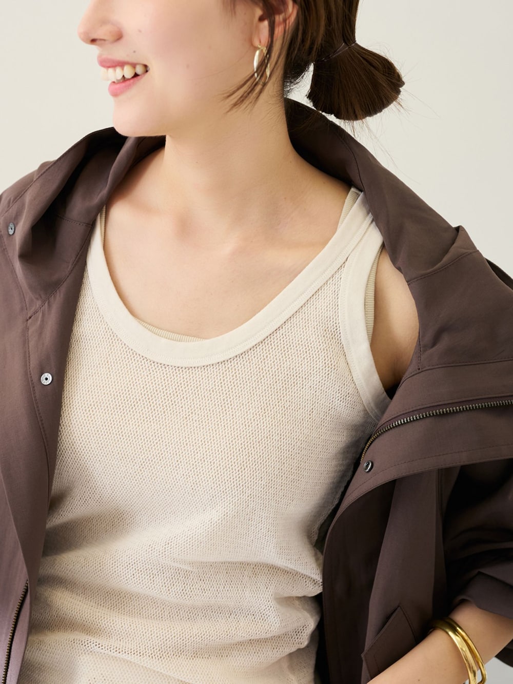 ホワイト系のカーゴパンツ、ブラウン系のマウンテンパーカー、ホワイト系のタンクトップを着用したレディースの冬コーディネートの4枚目の写真