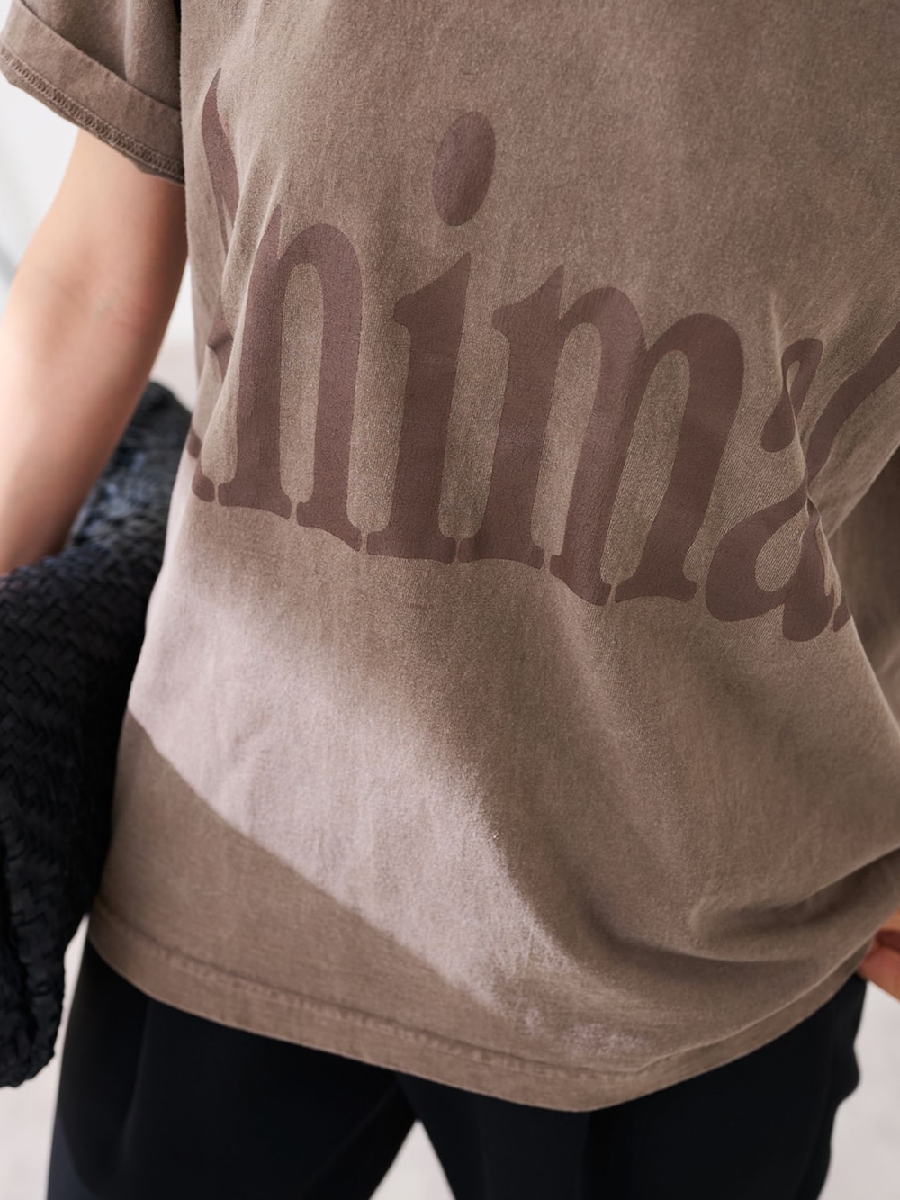 ブラック系のスラックス、ブラウン系のTシャツ/カットソー、ブラック系のトートバッグを着用したレディースの春コーディネートの7枚目の写真