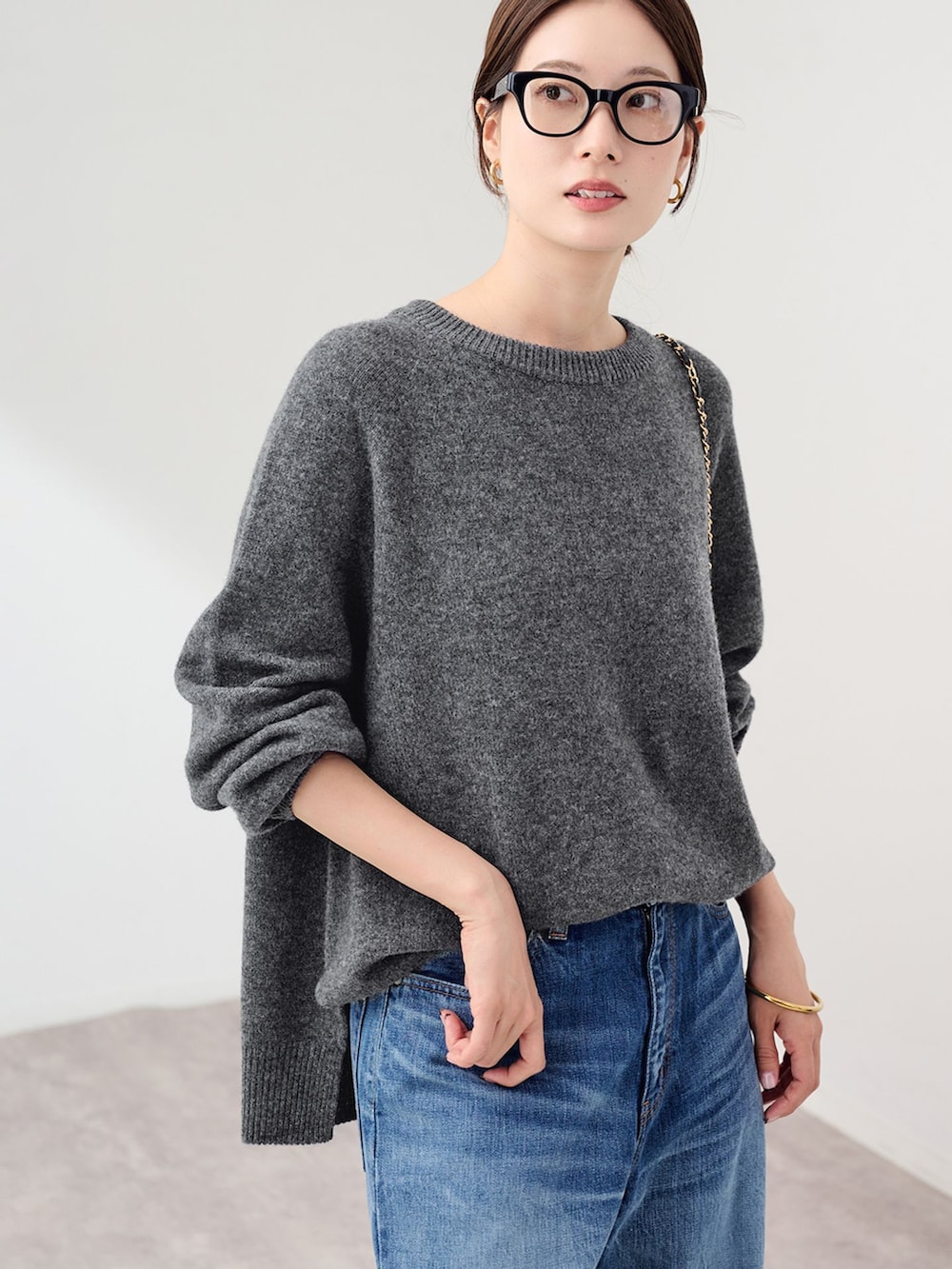 ブルー系のデニムパンツ、グレー系のニット/セーター、ブラック系のスリッポンを着用したレディースの秋コーディネートの5枚目の写真