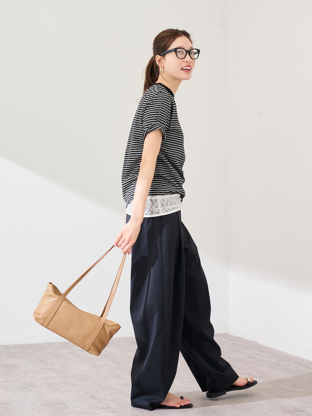 ブラック系のスラックス、ブラック系のTシャツ/カットソーを着用したレディースの春コーディネートの2枚目の写真