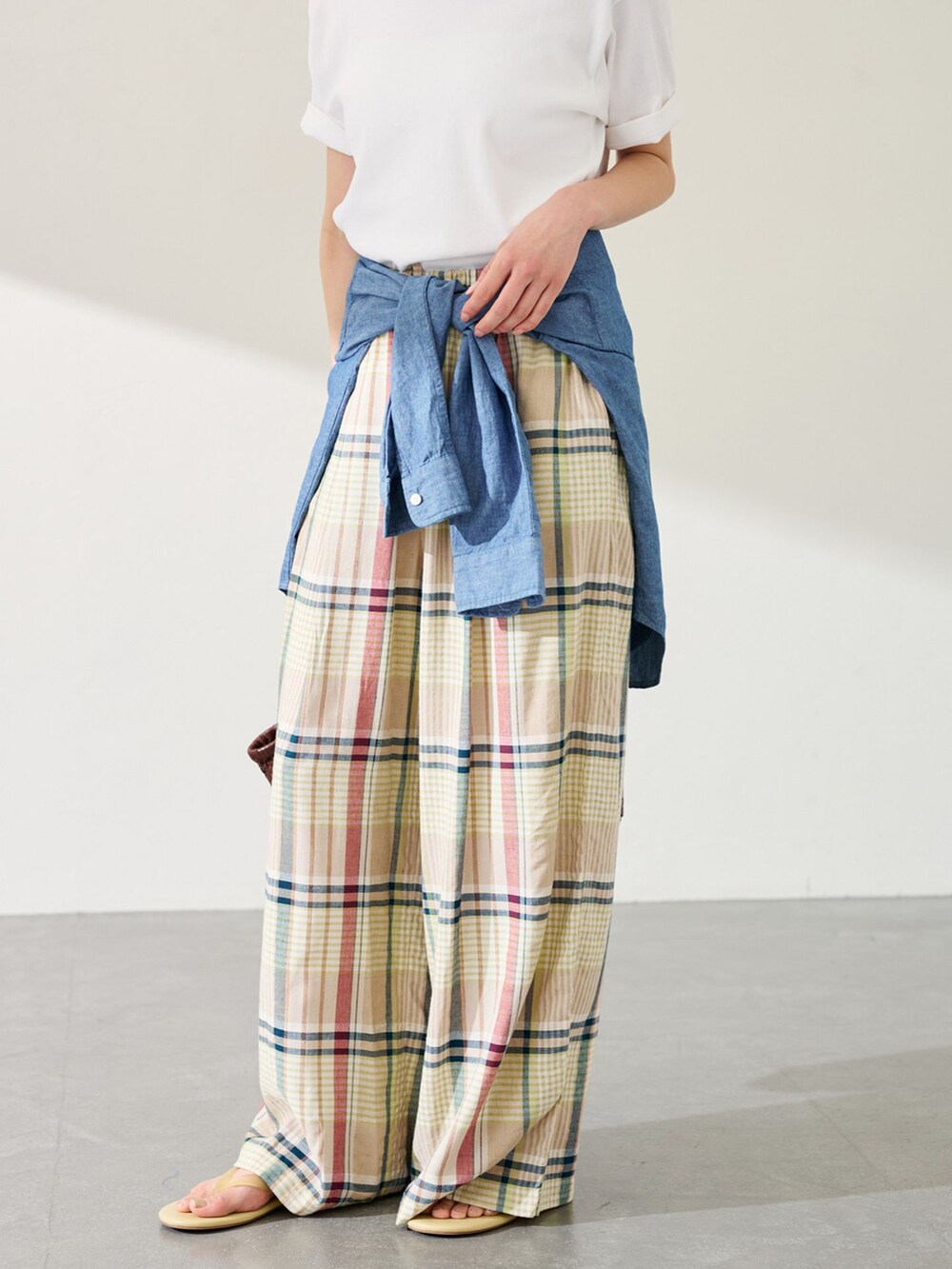 イエロー系のスラックス、ブルー系のシャツ/ブラウス、ホワイト系のTシャツ/カットソーを着用したレディースの春コーディネートの3枚目の写真