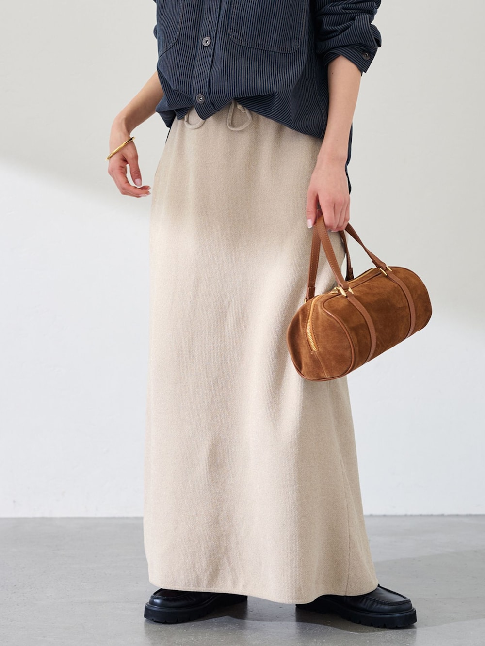 ブラック系のシャツ/ブラウス、ベージュ系のスカート、イエロー系のショルダーバッグを着用したレディースの冬コーディネートの2枚目の写真