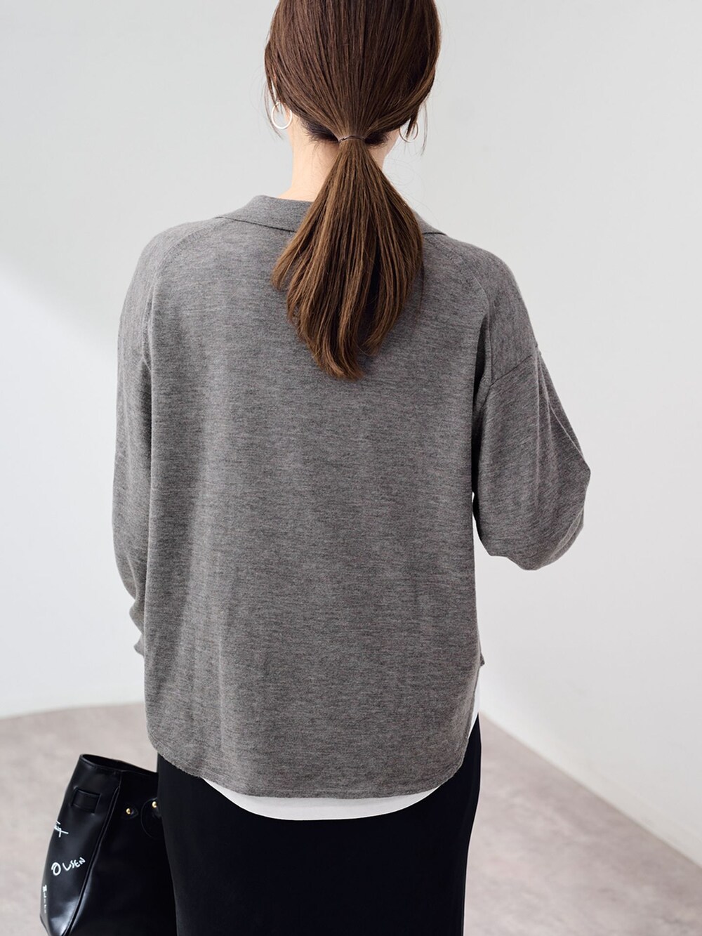 ブラック系のスカート、ホワイト系のTシャツ/カットソー、グレー系のニット/セーターを着用したレディースの秋コーディネートの8枚目の写真
