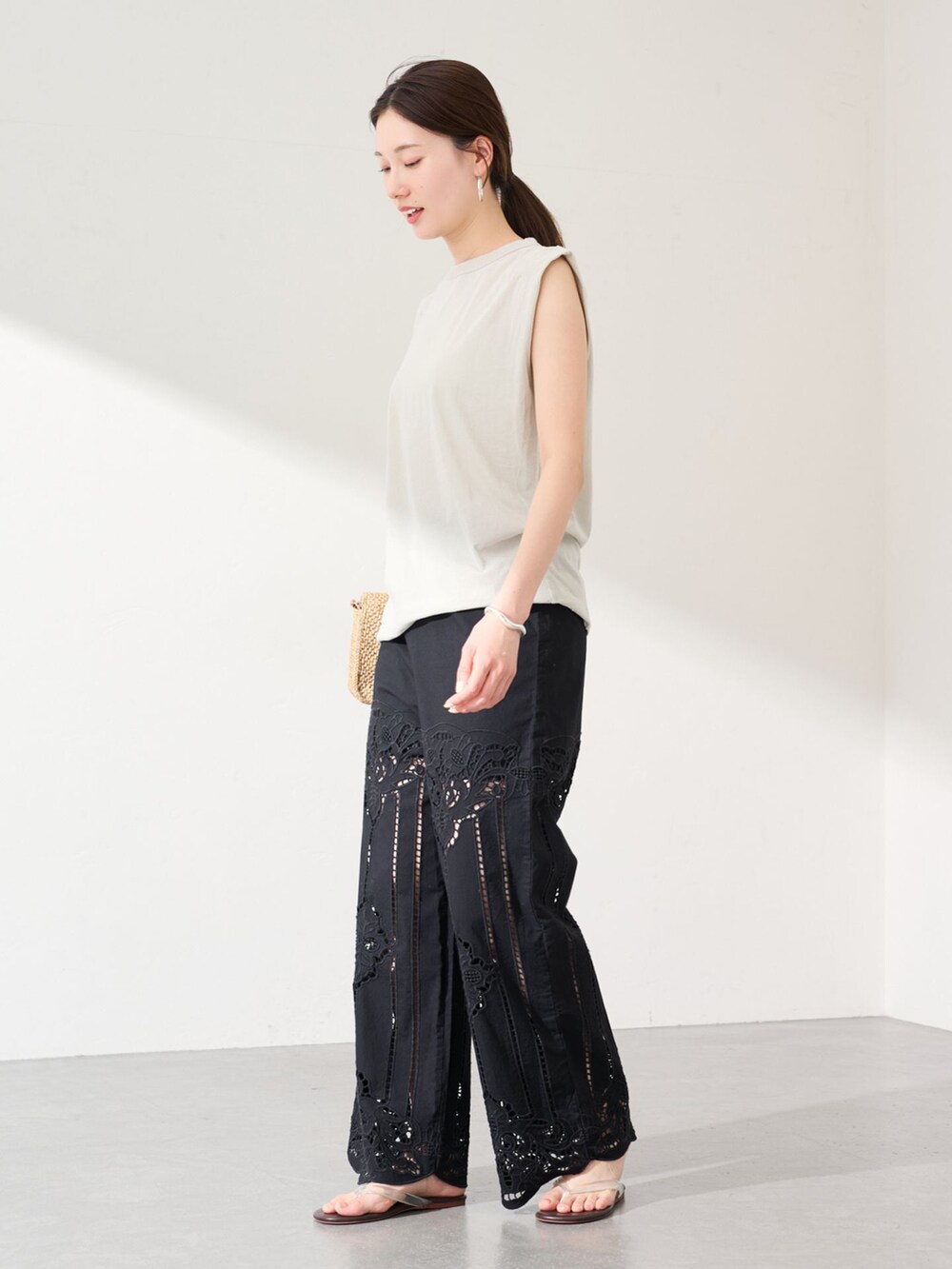 ブラック系のその他パンツ、ベージュ系のTシャツ/カットソー、ブラウン系のサンダルを着用したレディースの春コーディネートの2枚目の写真