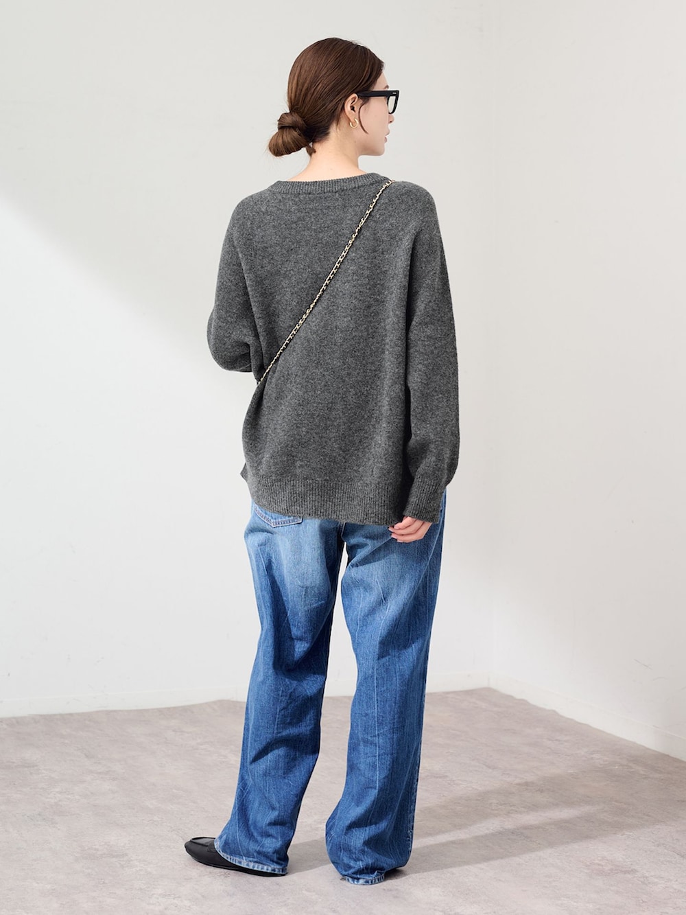 ブルー系のデニムパンツ、グレー系のニット/セーター、ブラック系のスリッポンを着用したレディースの秋コーディネートの3枚目の写真