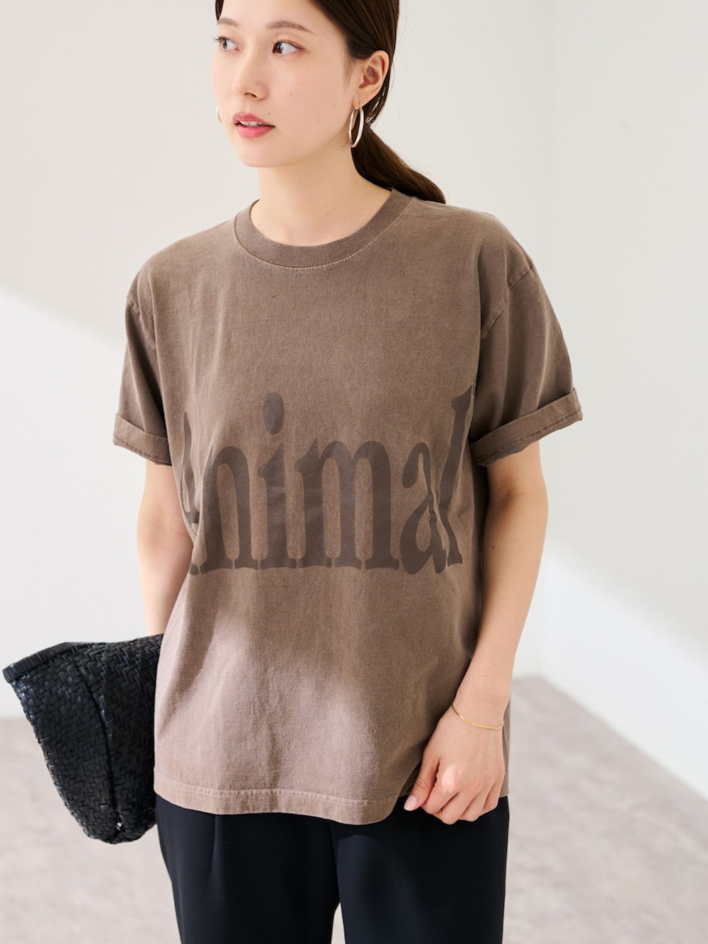 ブラック系のスラックス、ブラウン系のTシャツ/カットソー、ブラック系のトートバッグを着用したレディースの春コーディネートの4枚目の写真