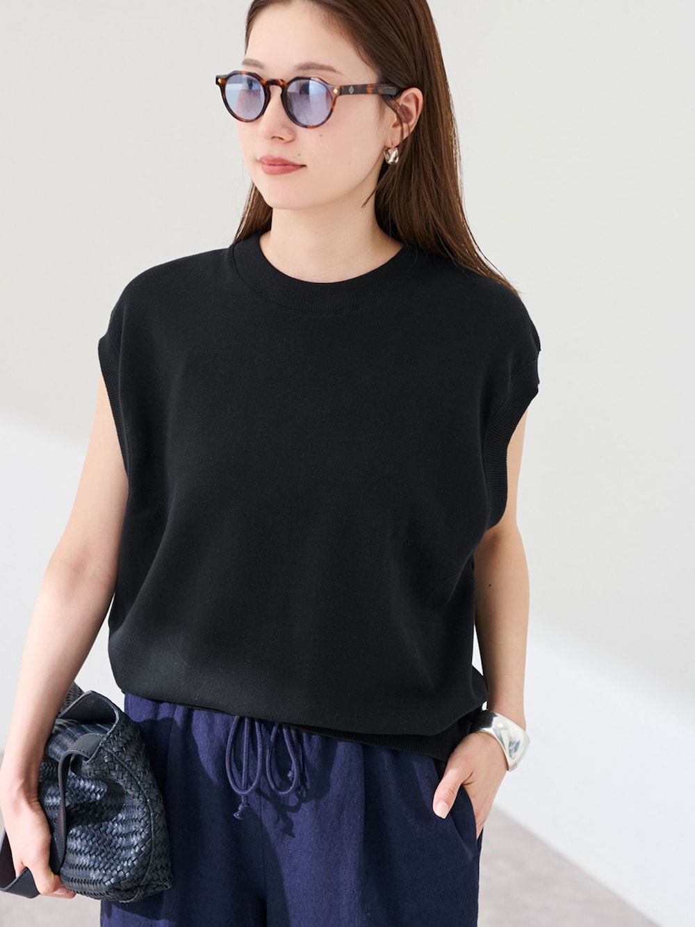 ブルー系のその他パンツ、ブラック系のTシャツ/カットソー、ブラック系のハンドバッグを着用したレディースの春コーディネートの4枚目の写真