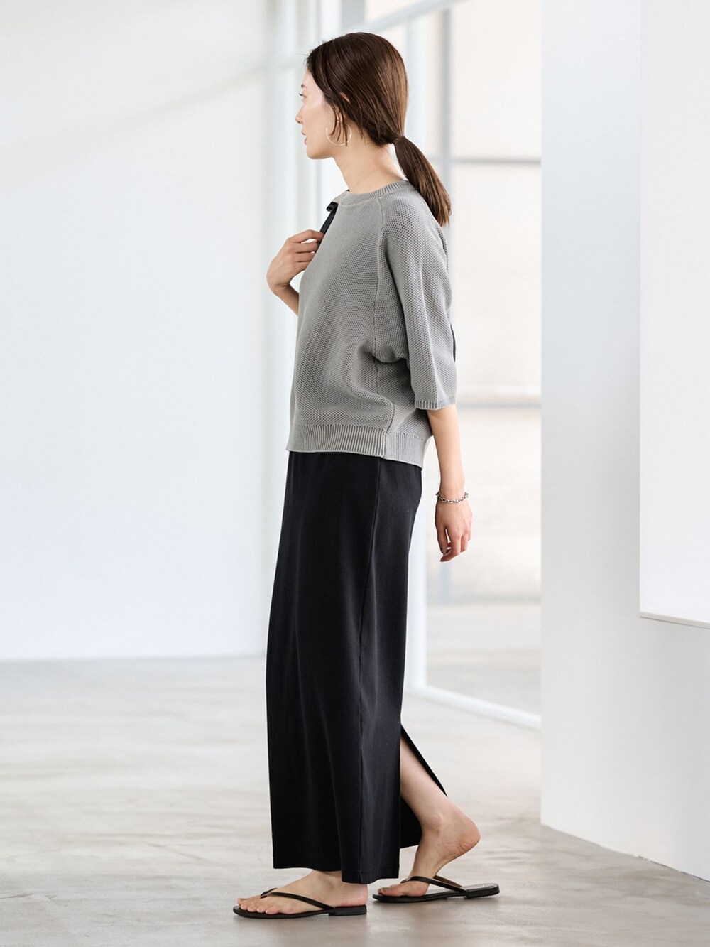 ブラック系のスカート、グリーン系のニット/セーターを着用したレディースの冬コーディネートの2枚目の写真