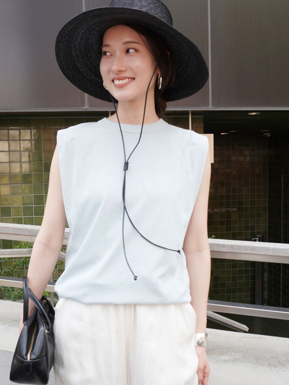 ホワイト系のその他パンツ、ブルー系のTシャツ/カットソー、ブラック系のショルダーバッグを着用したレディースの春コーディネートの2枚目の写真