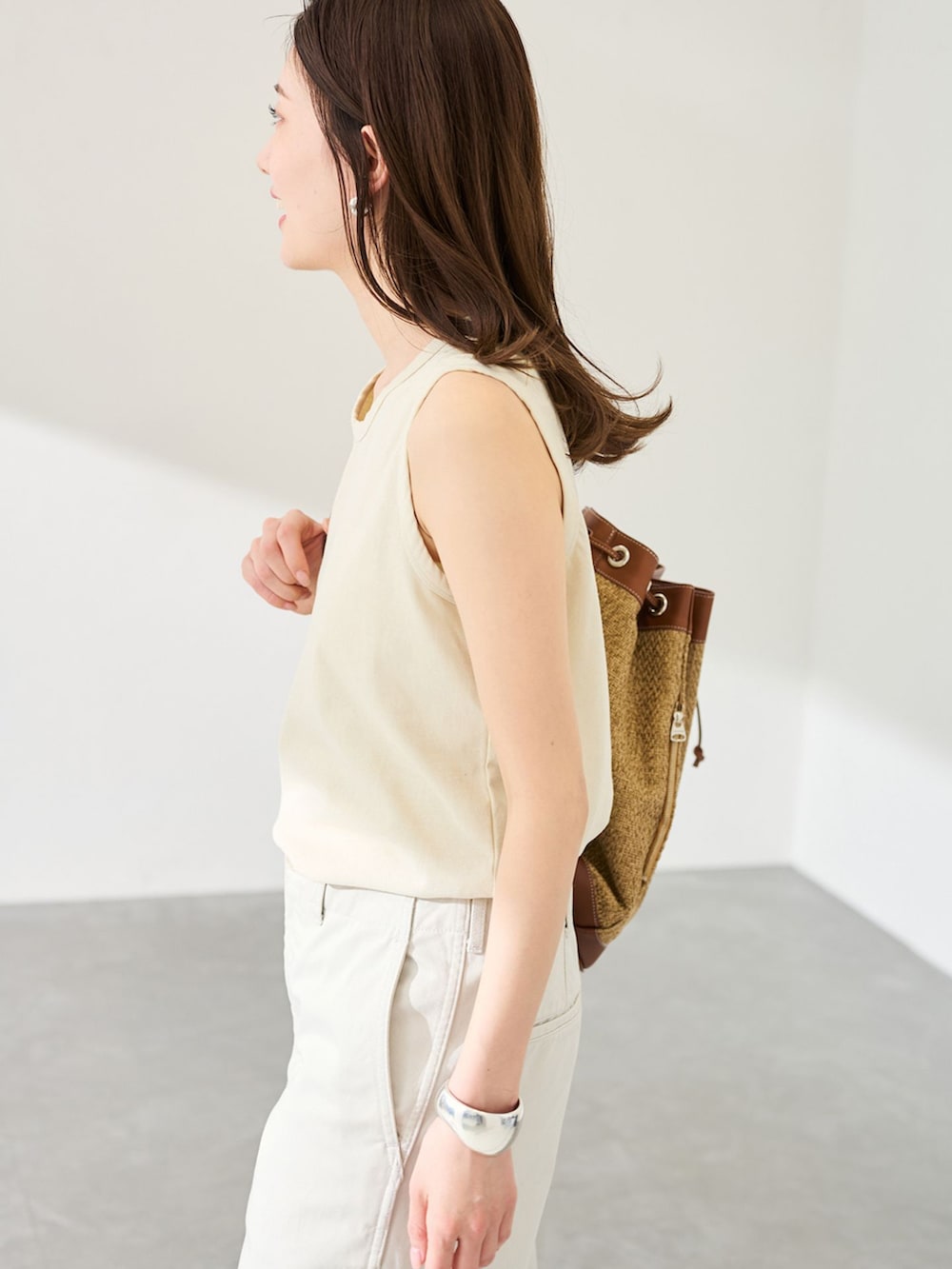 ホワイト系のチノパンツ、イエロー系のTシャツ/カットソー、ベージュ系のバックパック/リュックを着用したレディースの春コーディネートの5枚目の写真