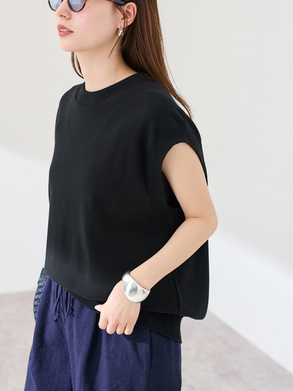 ブルー系のその他パンツ、ブラック系のTシャツ/カットソー、ブラック系のハンドバッグを着用したレディースの春コーディネートの5枚目の写真