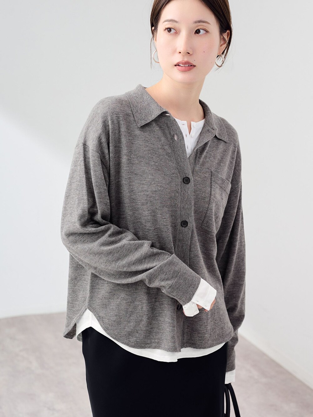 ブラック系のスカート、ホワイト系のTシャツ/カットソー、グレー系のニット/セーターを着用したレディースの秋コーディネートの6枚目の写真