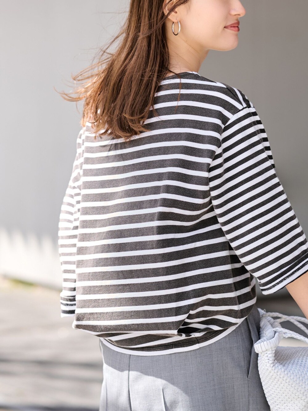 グレー系のスラックス、ブラック系のTシャツ/カットソーを着用したレディースの春コーディネートの5枚目の写真