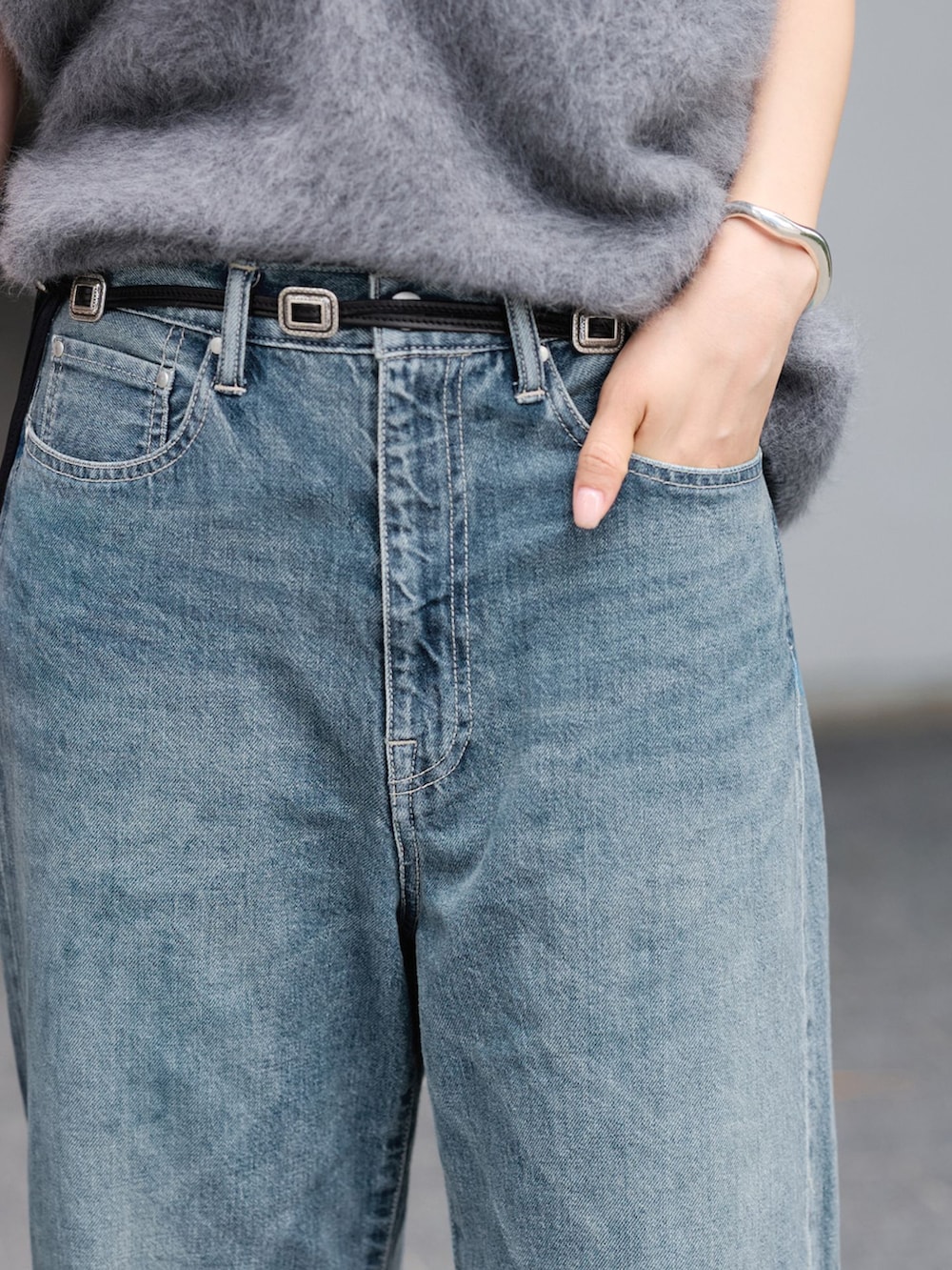ブルー系のデニムパンツ、グレー系のベスト、ブラック系のハンドバッグを着用したレディースの夏コーディネートの8枚目の写真