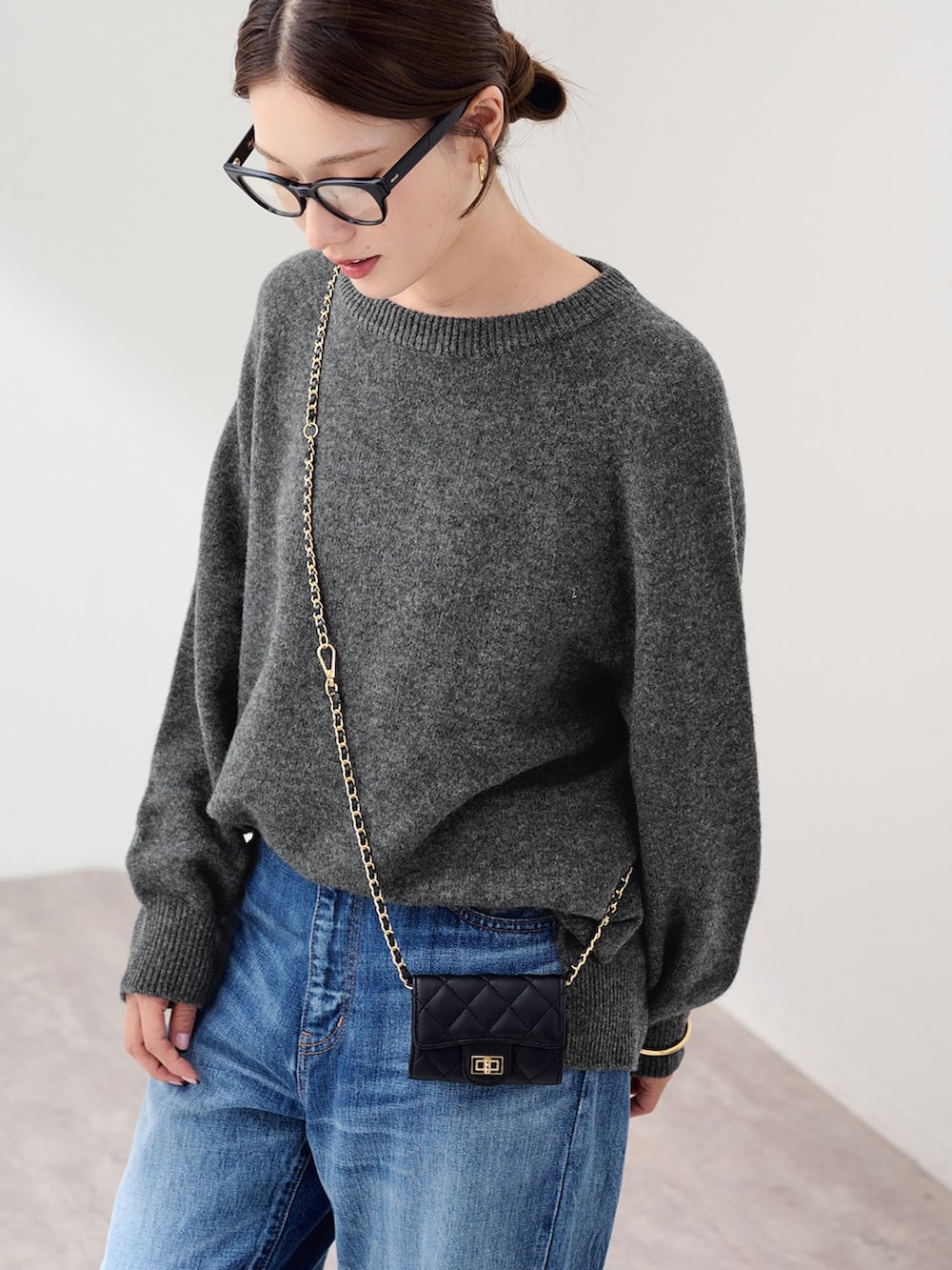 ブルー系のデニムパンツ、グレー系のニット/セーター、ブラック系のスリッポンを着用したレディースの秋コーディネートの4枚目の写真
