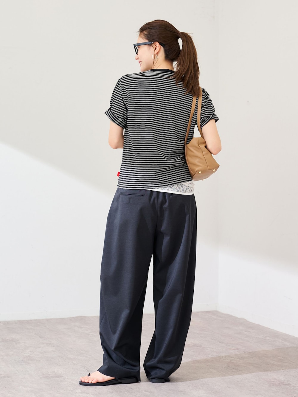 ブラック系のスラックス、ブラック系のTシャツ/カットソーを着用したレディースの春コーディネートの3枚目の写真