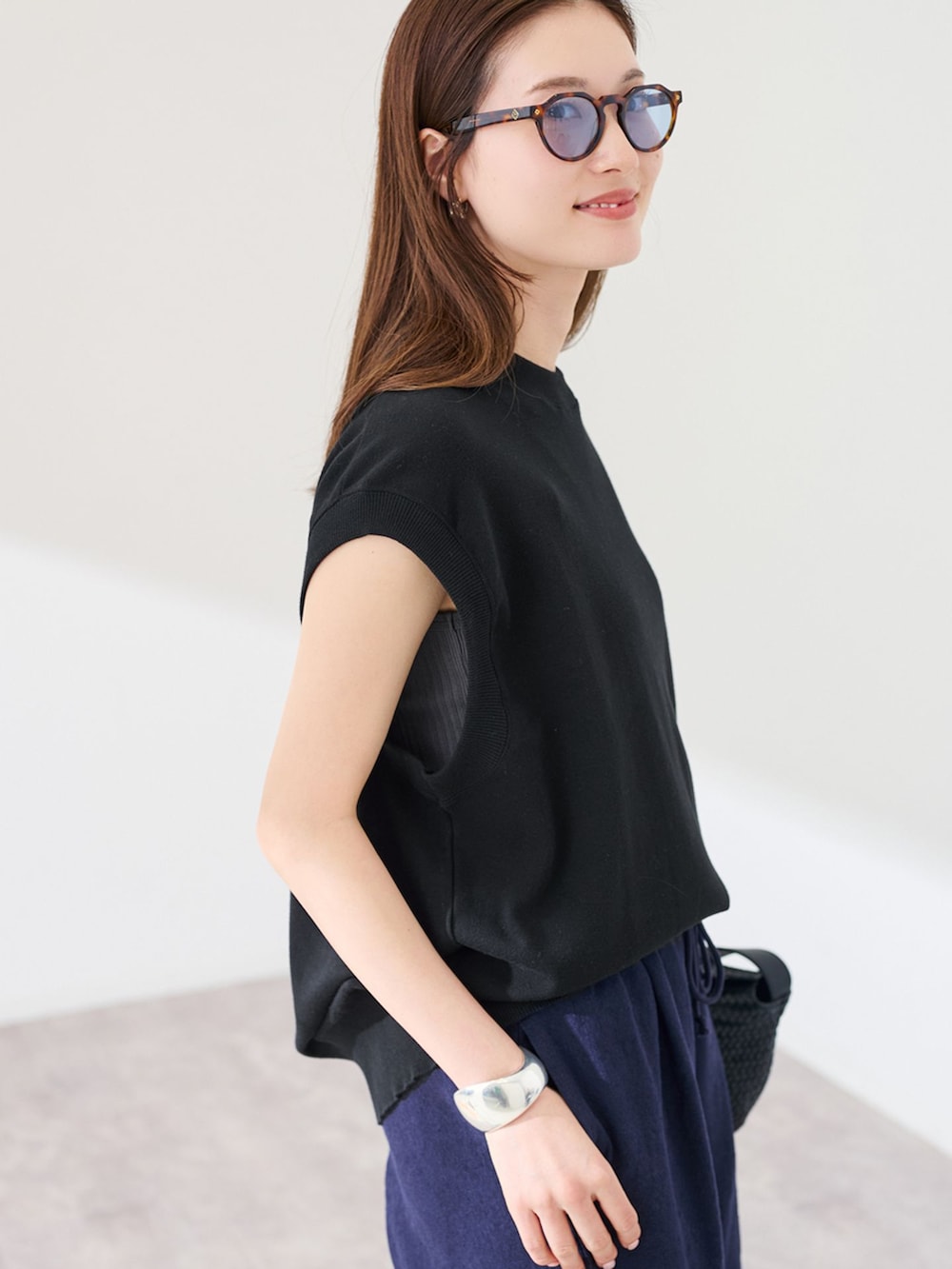 ブルー系のその他パンツ、ブラック系のTシャツ/カットソー、ブラック系のハンドバッグを着用したレディースの春コーディネートの7枚目の写真