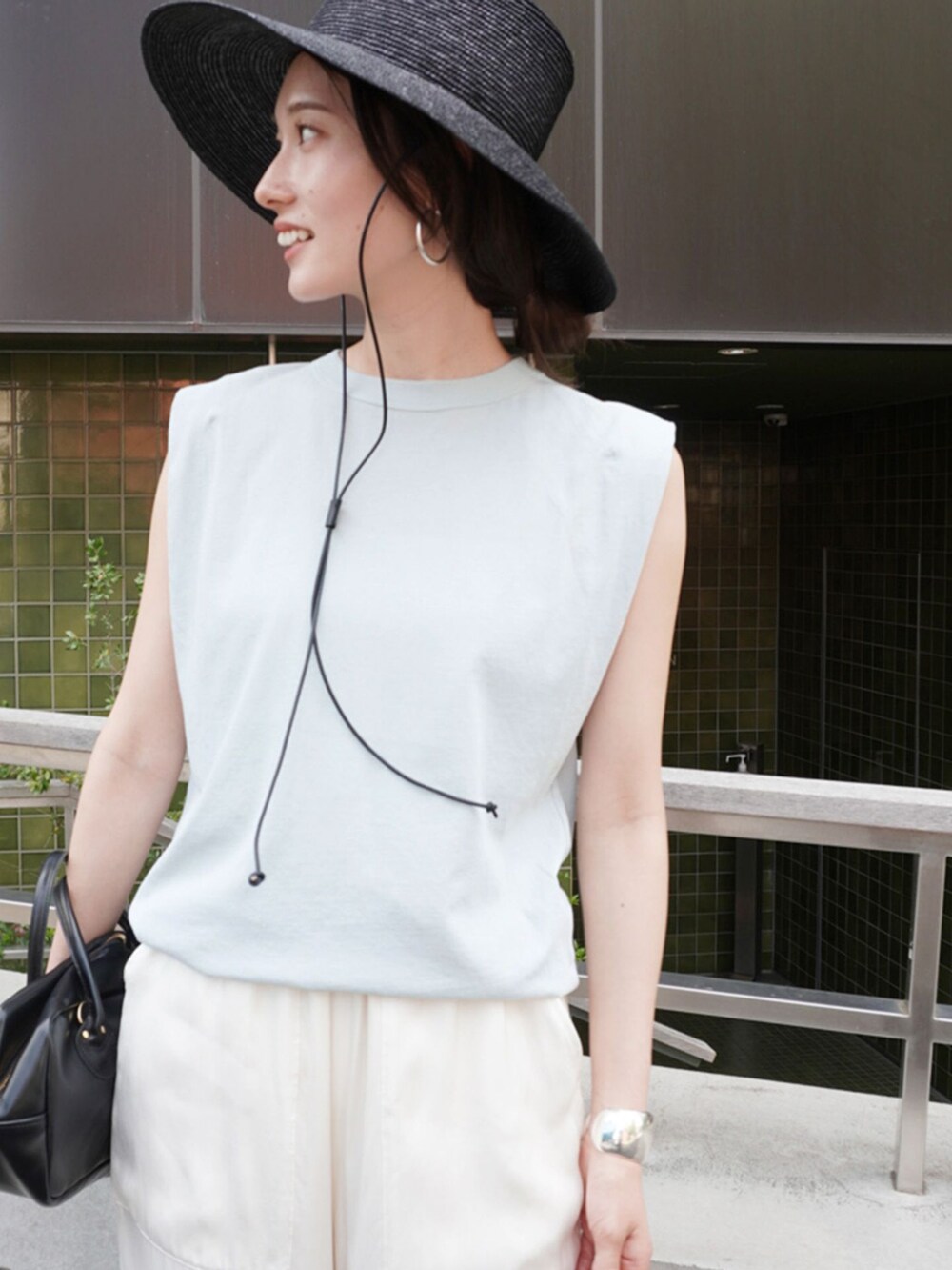 ホワイト系のその他パンツ、ブルー系のTシャツ/カットソー、ブラック系のショルダーバッグを着用したレディースの春コーディネートの3枚目の写真