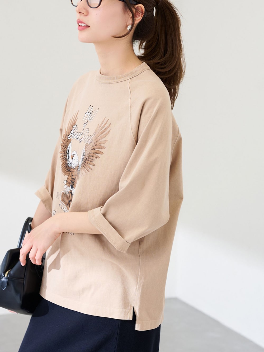 ブラック系のスカート、ベージュ系のTシャツ/カットソー、ブラック系のショルダーバッグを着用したレディースの冬コーディネートの4枚目の写真