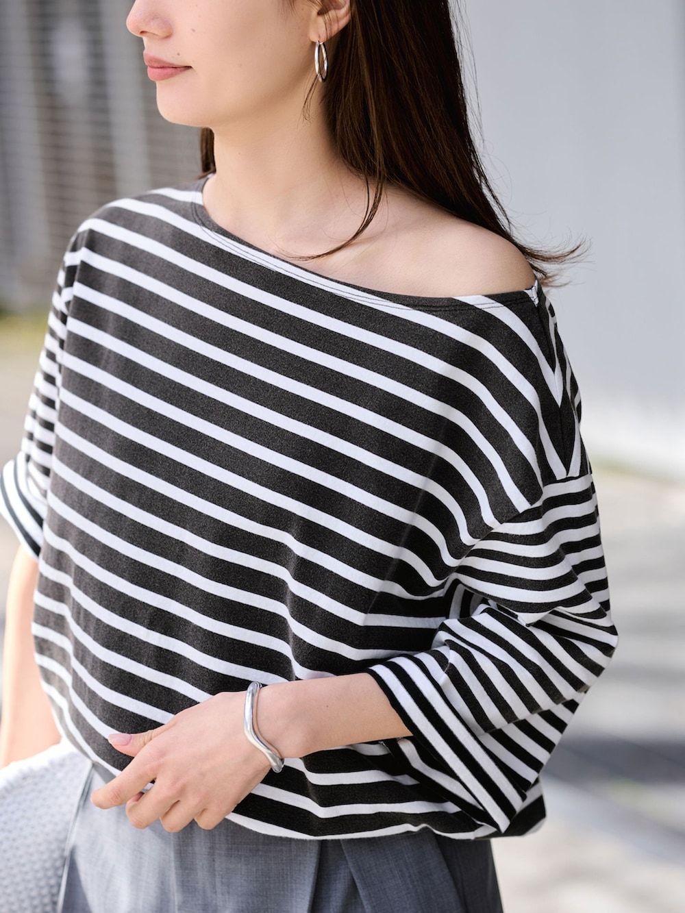 グレー系のスラックス、ブラック系のTシャツ/カットソーを着用したレディースの春コーディネートの7枚目の写真