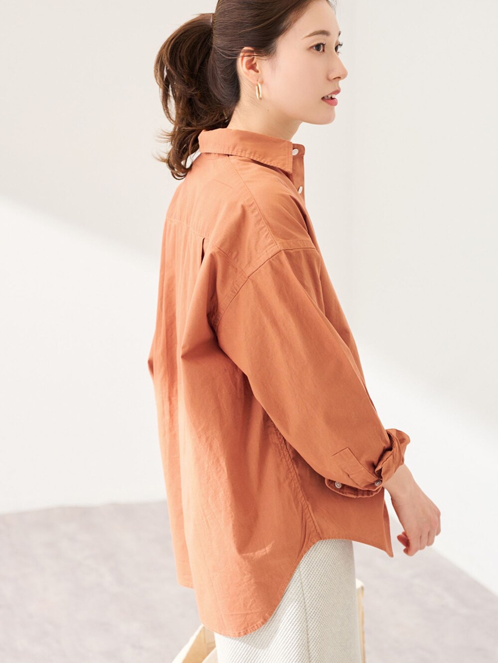 ブラウン系のシャツ/ブラウス、グレー系のスカート、ホワイト系のトートバッグを着用したレディースの冬コーディネートの4枚目の写真