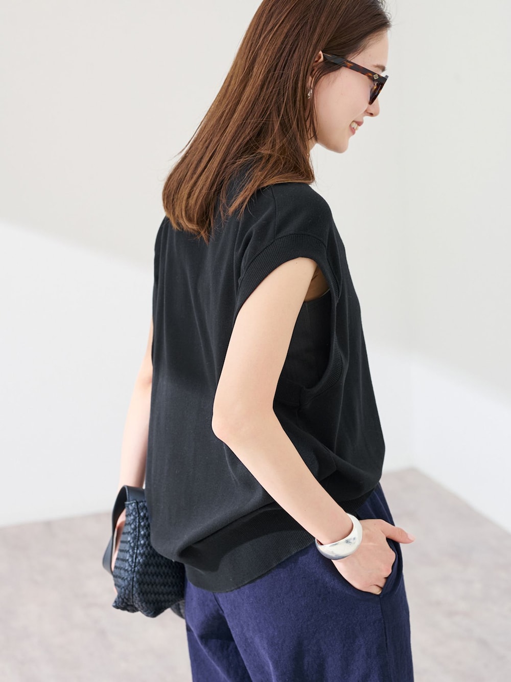 ブルー系のその他パンツ、ブラック系のTシャツ/カットソー、ブラック系のハンドバッグを着用したレディースの春コーディネートの6枚目の写真