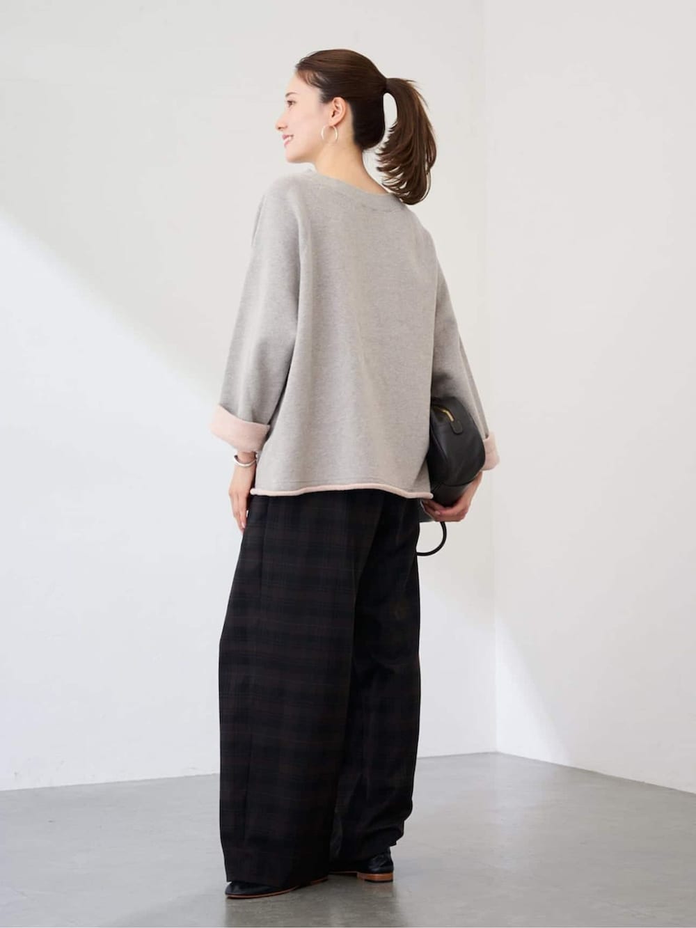 ブラウン系のその他パンツ、グレー系のスウェット、ブラック系のボストンバッグを着用したレディースの冬コーディネートの3枚目の写真