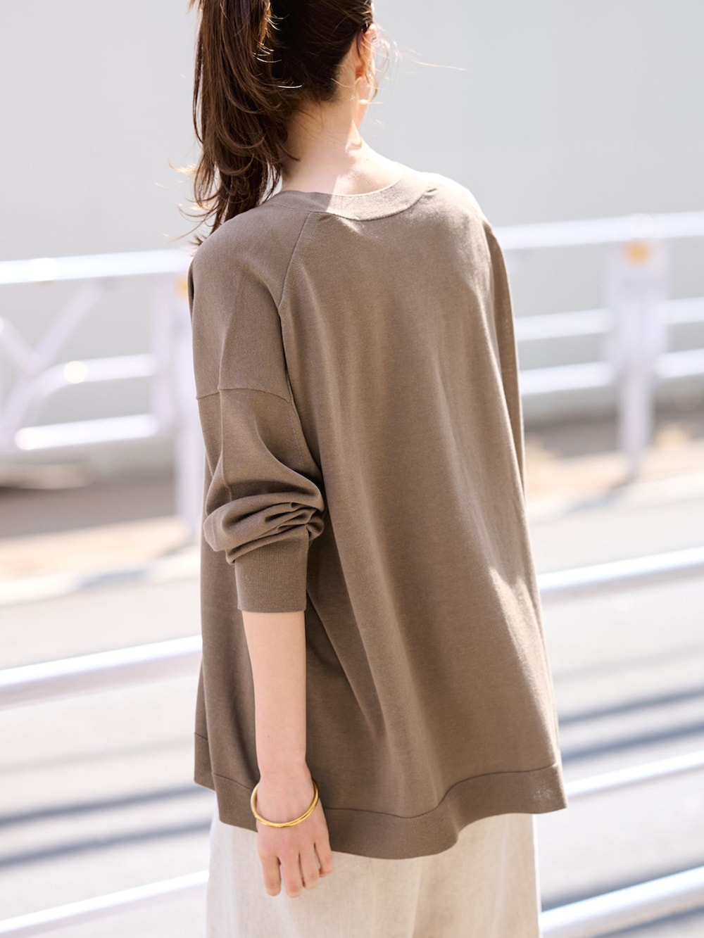 ベージュ系のその他パンツ、ブラウン系のカーディガン/ボレロ、ホワイト系のボストンバッグを着用したレディースの春コーディネートの6枚目の写真