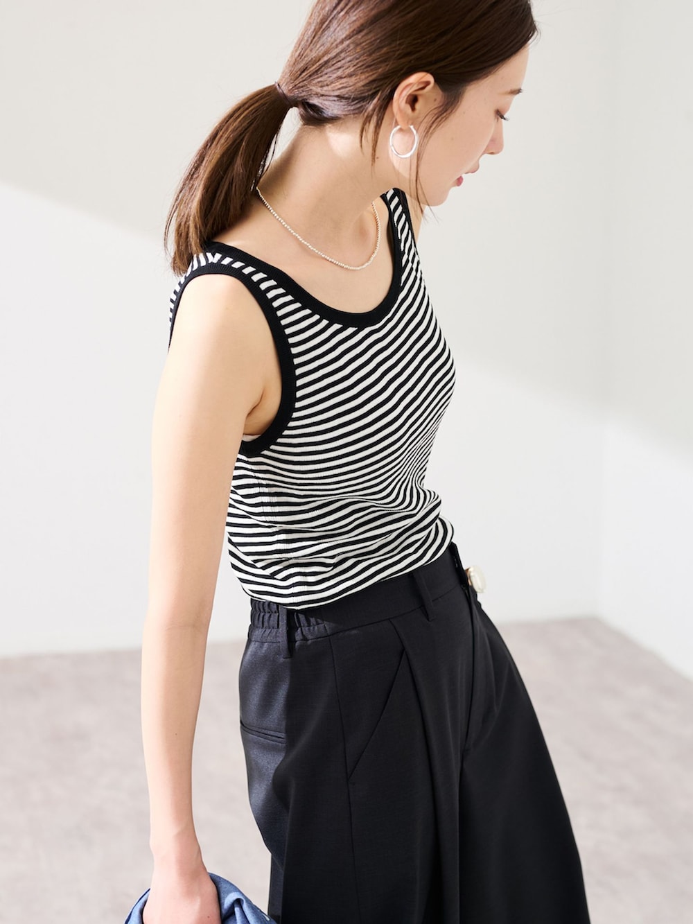 ブラック系のスラックス、ブルー系のシャツ/ブラウス、ホワイト系のタンクトップを着用したレディースの春コーディネートの6枚目の写真