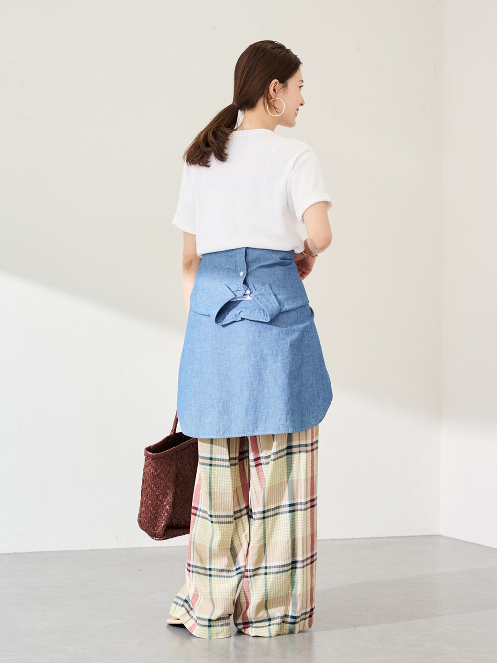 イエロー系のスラックス、ブルー系のシャツ/ブラウス、ホワイト系のTシャツ/カットソーを着用したレディースの春コーディネートの2枚目の写真