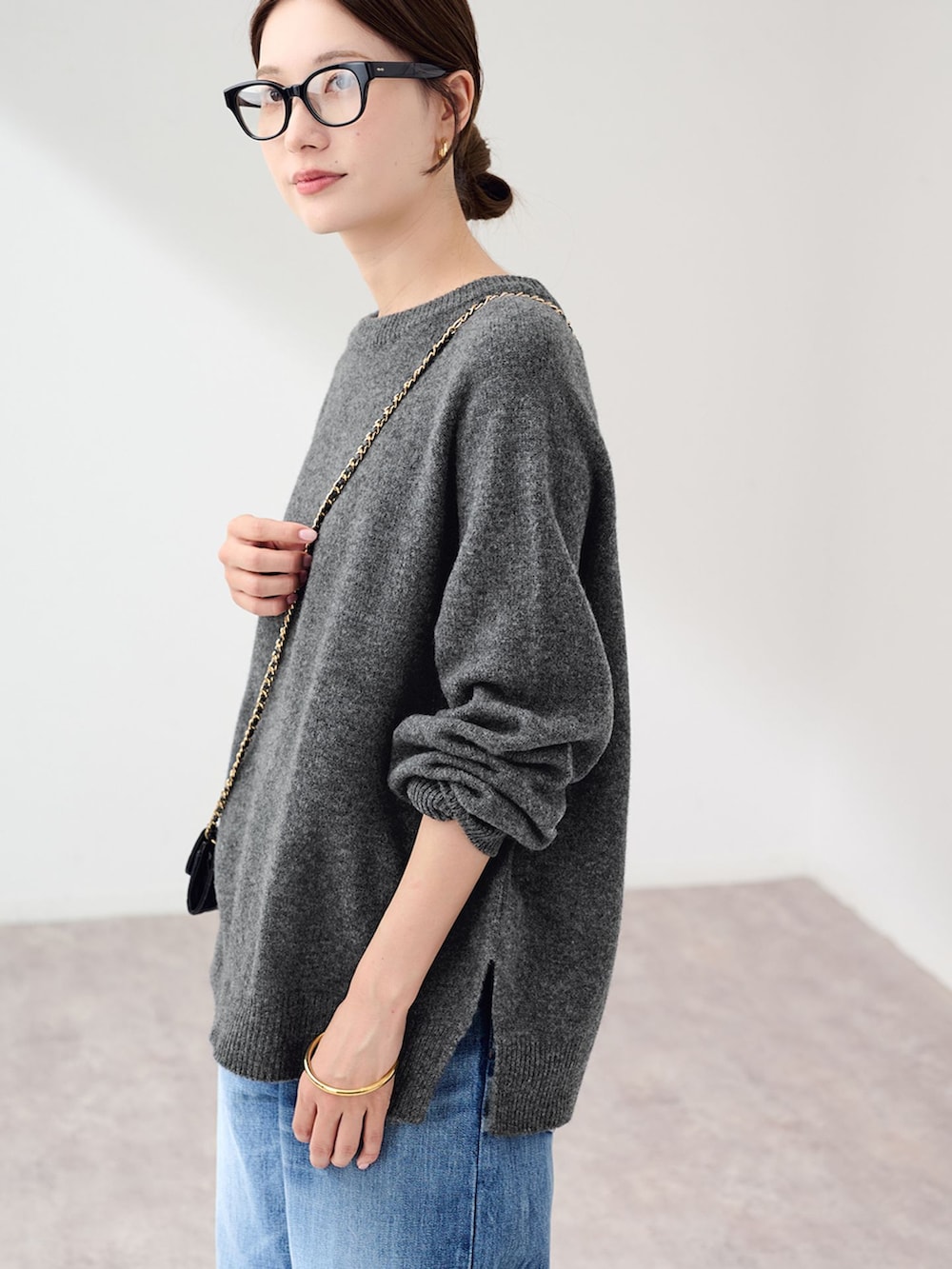 ブルー系のデニムパンツ、グレー系のニット/セーター、ブラック系のスリッポンを着用したレディースの秋コーディネートの6枚目の写真