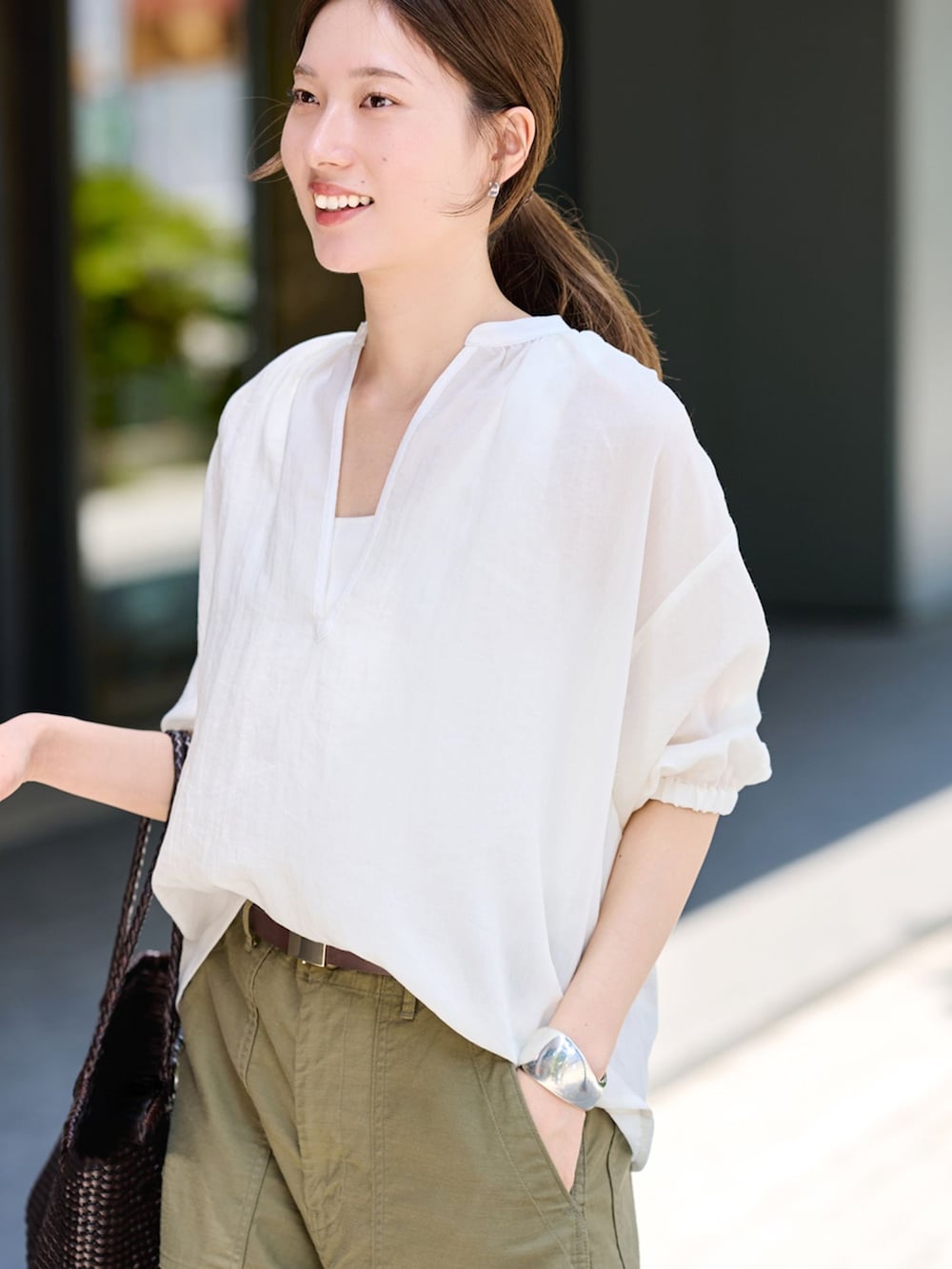 グリーン系のカーゴパンツ、ホワイト系のシャツ/ブラウス、ブラック系のサンダルを着用したレディースの夏コーディネートの4枚目の写真