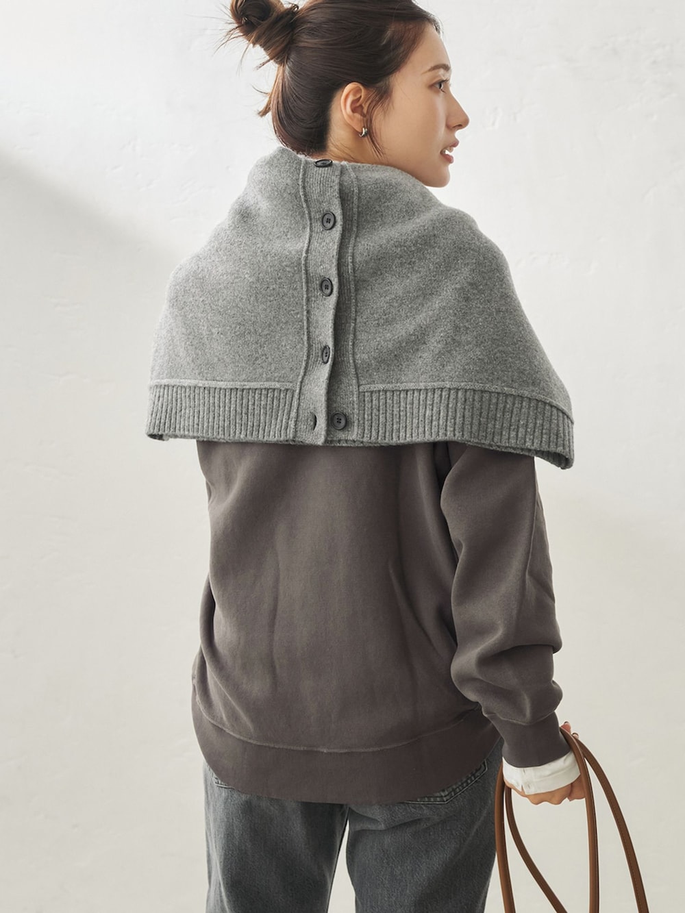 ブラック系のデニムパンツ、ホワイト系のTシャツ/カットソー、ブラック系のスウェットを着用したレディースの秋コーディネートの6枚目の写真