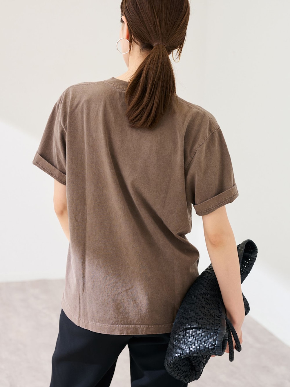 ブラック系のスラックス、ブラウン系のTシャツ/カットソー、ブラック系のトートバッグを着用したレディースの春コーディネートの6枚目の写真