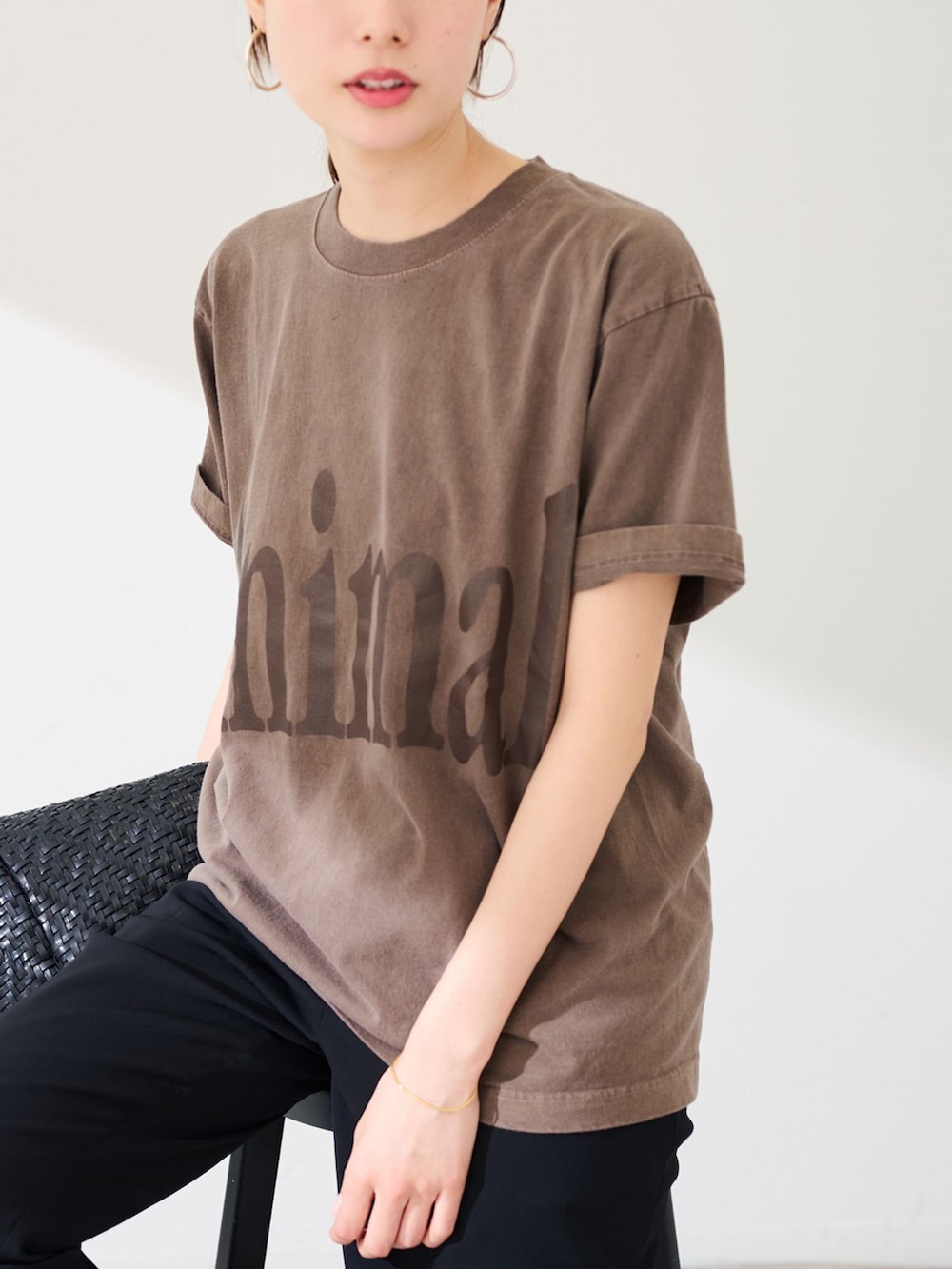 ブラック系のスラックス、ブラウン系のTシャツ/カットソー、ブラック系のトートバッグを着用したレディースの春コーディネートの9枚目の写真