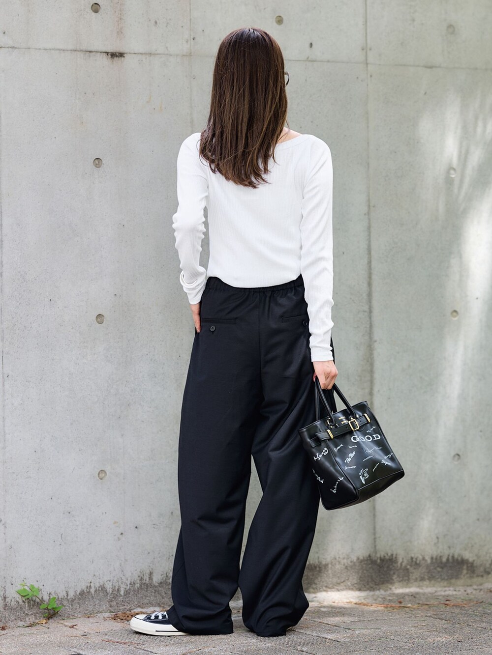 ブラック系のスラックス、ホワイト系のTシャツ/カットソー、ブラック系のショルダーバッグを着用したレディースの夏コーディネートの3枚目の写真