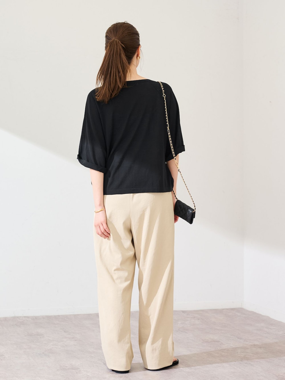 ベージュ系のその他パンツ、ブラック系のニット/セーターを着用したレディースの春コーディネートの3枚目の写真