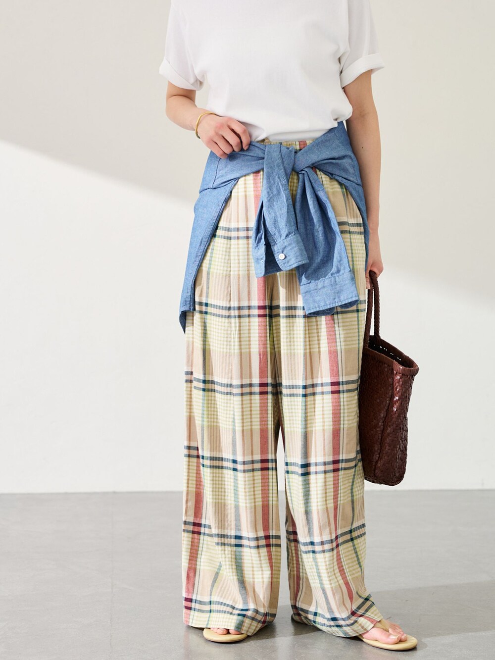 イエロー系のスラックス、ブルー系のシャツ/ブラウス、ホワイト系のTシャツ/カットソーを着用したレディースの春コーディネートの6枚目の写真