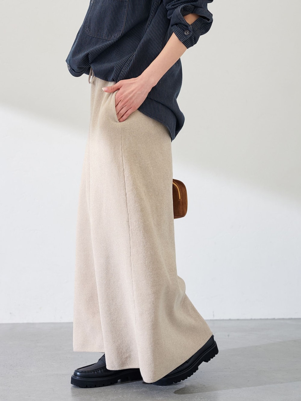 ブラック系のシャツ/ブラウス、ベージュ系のスカート、イエロー系のショルダーバッグを着用したレディースの冬コーディネートの3枚目の写真